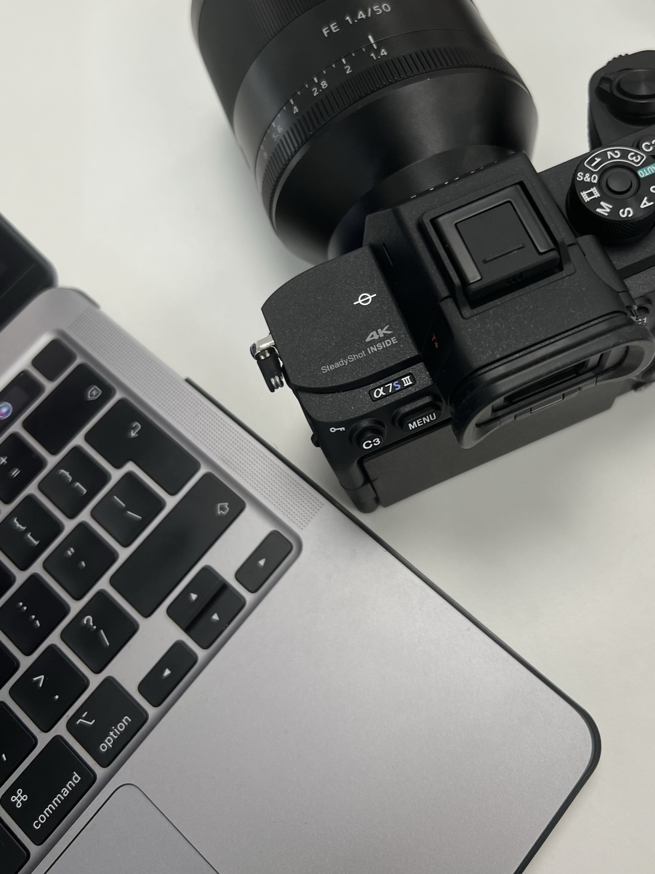 Camera body beside a laptop