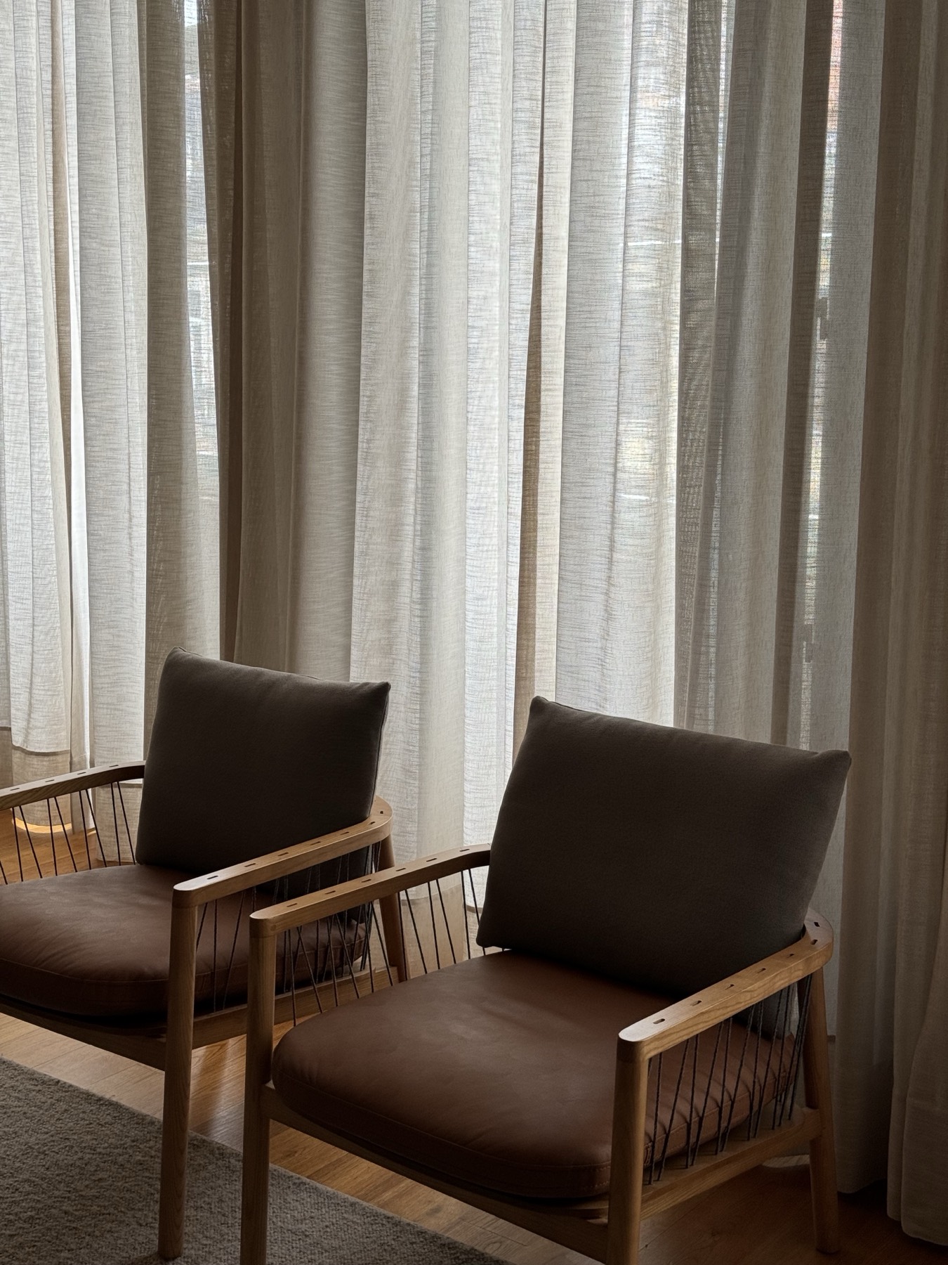 Two chairs beside a curtained window