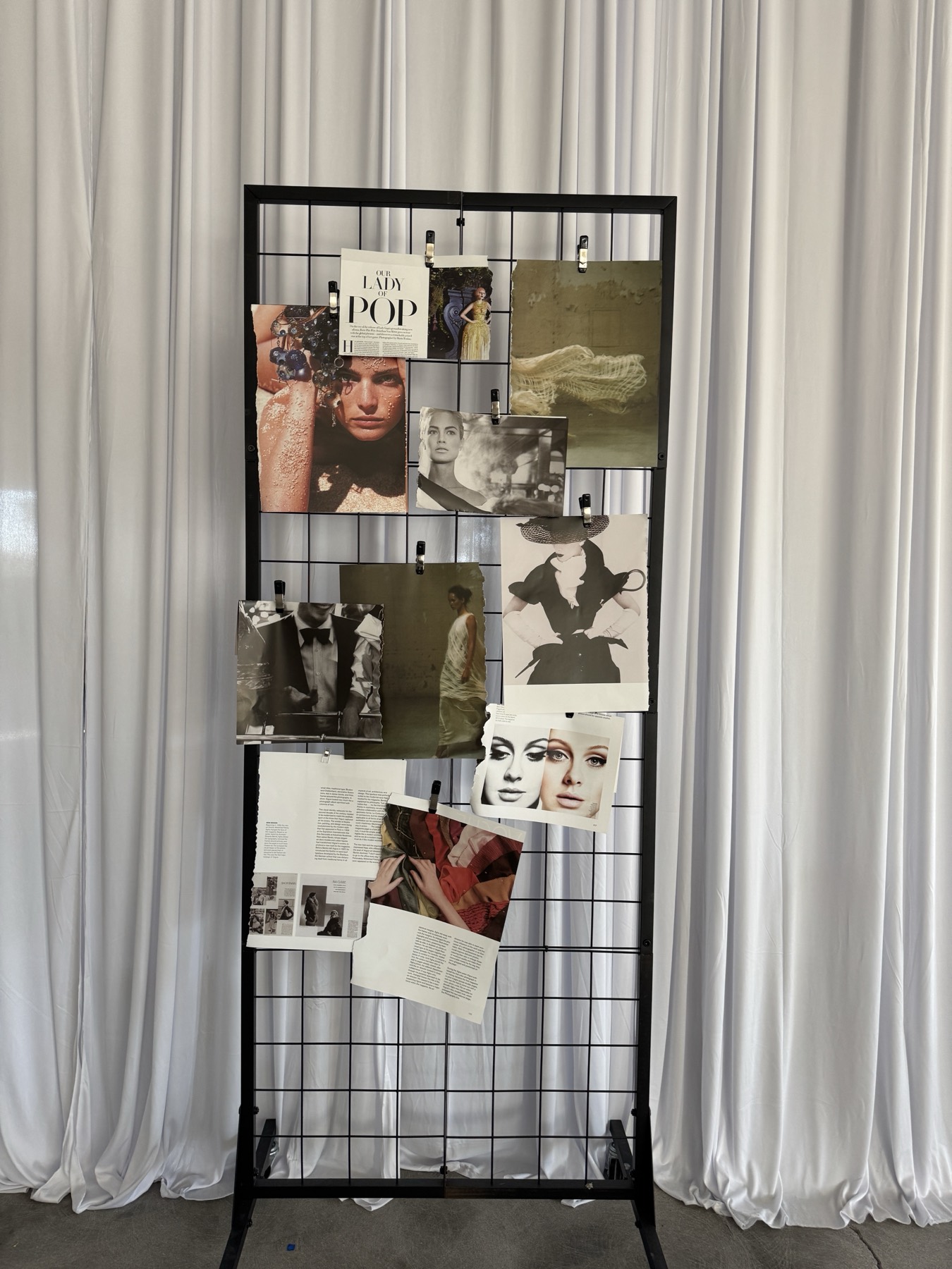 Editorial tear sheets clipped to a grid stand